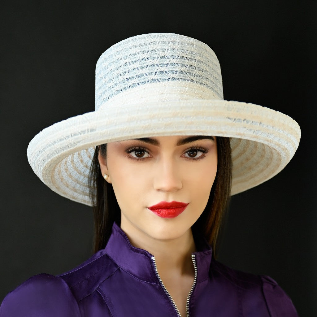 A woman wearing a cream horsehair dress hat with a subtle pattern.