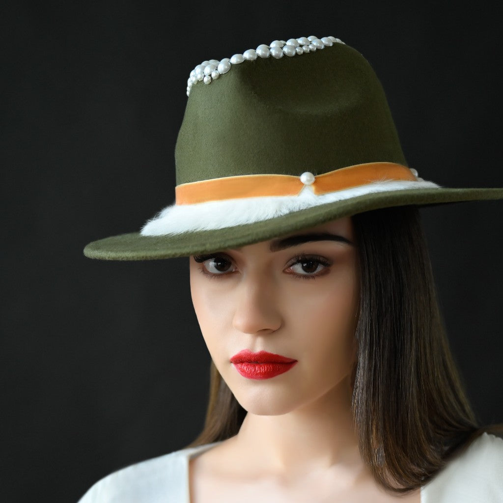 A woman wearing an olive green fedora with a velvet trim and a pearl design.