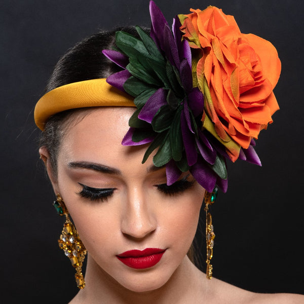 mustard color fascinator with orange and purple flower